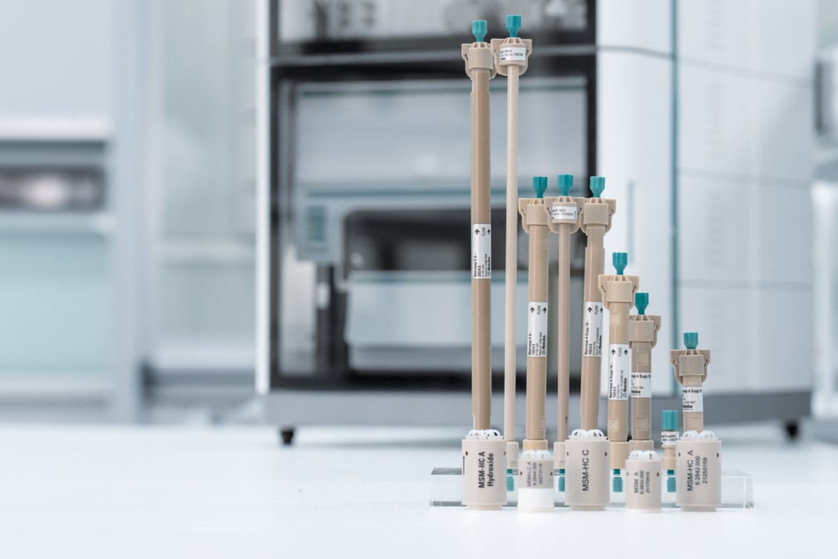 man holding an IC column in his hands, more IC column packages in the background on a table